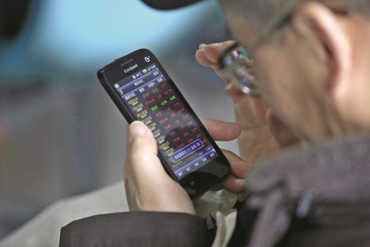 An investor checks stock information on a mobile phone at a brokerage house in Shanghai. Foreign investors have been wary of entering Chinese markets following heavy-handed intervention by authorities last year as they moved to prevent a rapid 40% slide in stocks from turning into a full-blown financial crisis.