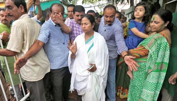 West Bengal Chief Minister Mamata Banerjee waves towards her supporters outside her residence after her Trinamool Congress Party won a resounding victory in assembly elections.