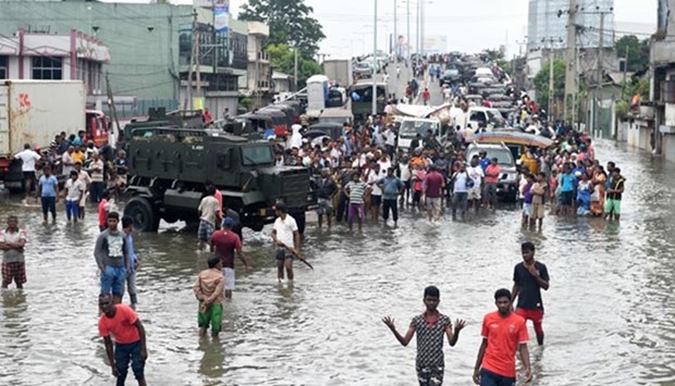 Sri Lankan residents make their way through floodwaters in Colombo
