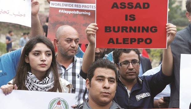 Protesters hold up placards as they take part in a sit-in in solidarity with the people of Aleppo, in front of the offices of the UN headquarters in Beirut, Lebanon yesterday.