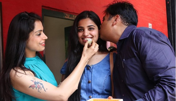 Srishti Ailawadi, who secured 97.8% in CBSEu2019s Class 12 exam, is given a sweet by her mother in New Delhi yesterday.