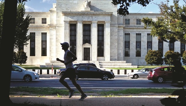 A runner passes the Federal Reserve building in Washington, DC. Wall Street is pushing back against the Fedu2019s tougher tone on raising interest rates, as strategists see the bond market warning of potential consequences.