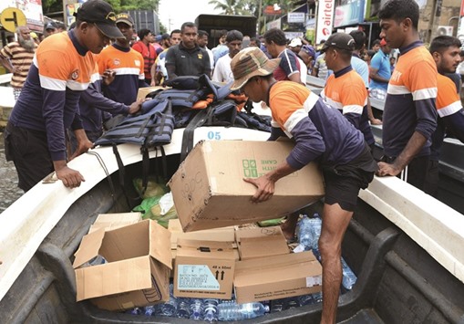 Sri Lankan navy personnel loading collected food and water for flood victims in the Kolonnawa suburb of Colombo yesterday.