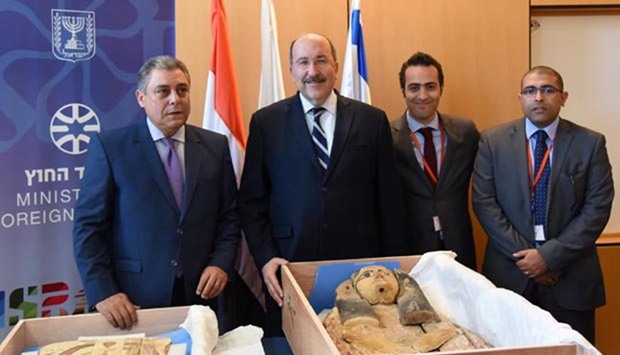 Egypt's ambassador to Israel Hazem Khairat (left) and Dore Gold (second left), director-general of Israel's foreign ministry, pose with Egyptian diplomats in front of ancient sarcophagi covers, which Israel handed back to Egypt, in Jerusalem on Sunday.
