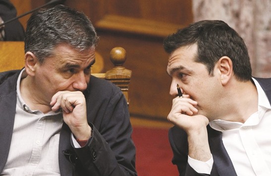 Greek Prime Minister Alexis Tsipras and Finance Minister Euclid Tsakalotos speak during a parliamentary session, before a vote on a new package of tax hikes and reforms in Athens yesterday.  Greece and its European creditors are locked in talks on how to reduce the countryu2019s debt burden, which the International Monetary Fund said must happen if it is to contribute any more of its own funds.