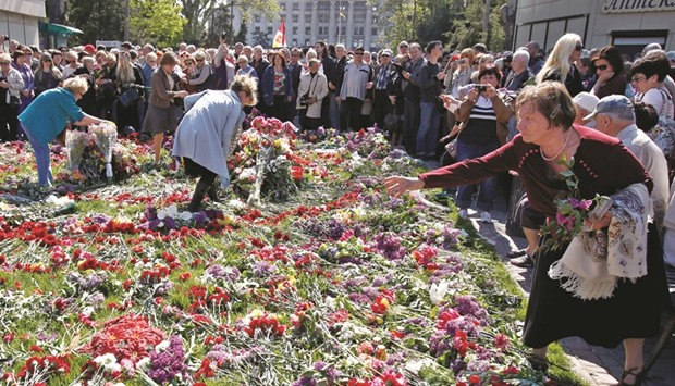 People lay flowers during a pro-Russia meet next to the Kulikove Pole Square in Odessa yesterday in memory of those who died in a fire at the Trade Union House two years ago.
