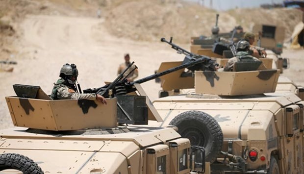 Vehicles of the Iraqi security forces are seen on the outskirts of Falluja on Monday.