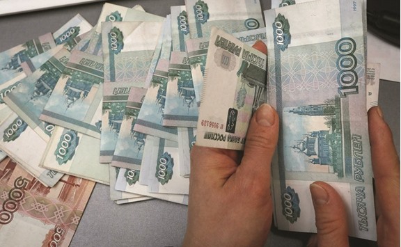 An employee counts Russian rouble banknotes at a shop selling home appliances in Krasnoyarsk, Russia. While the rouble has rebounded almost 30% since touching a record 85.999 versus the dollar on January 21, the currency suffered its worst weekly decline in three months in the five days ended on last Friday.