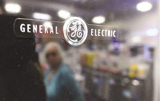 This file photo taken on January 15, 2016 shows a woman reflected on the door of a General Electric refrigerator at a store selling electronics and appliances in Montebello, California. The US industrial conglomerate is supporting Saudi Arabiau2019s recently unveiled plan to diversify the oil-dominated economy.