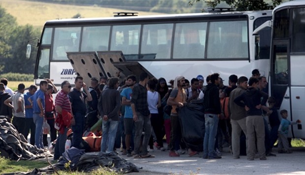 People board in a bus in order to leave the refugee makeshift camp on the Greek border