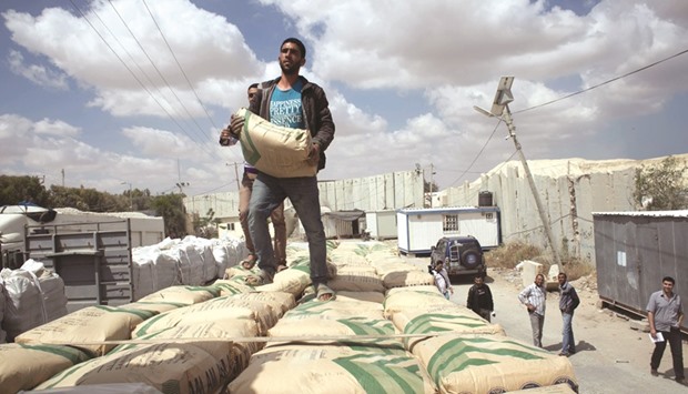Palestinian workers stand on a truck loaded with bags of cement after it entered the southern Gaza Strip from Israel through the Kerem Shalom crossing in Rafah yesterday.