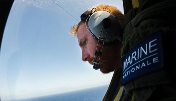 A French solider aboard an aircraft is looking out a window during searches for debris from the crashed EgyptAir flight over the Mediterranean Sea.