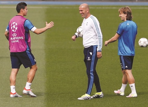 Real Madrid coach Zinedine Zidane with James Rodriguez (L) and Luka Modric (R) during training session.