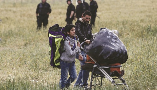 A migrant family carries their belongings during an evacuation operation by police forces at the border camp near the Greek-Macedonian border village of Idomeni.