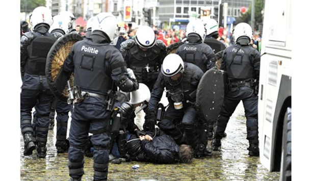 Riot police arrest a demonstrator yesterday during a national anti-austerity demonstration in Brussels.