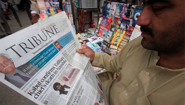 A man reads a newspaper containing news about the death of Afghan Taliban leader Mansour