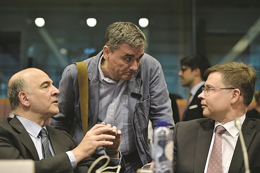European Economic and Financial Affairs commissioner Pierre Moscovici (left) chats with Greeceu2019s Finance Minister Euclid Tsakalotos (centre) and European Commission  vice-president Valdis Dombrovskis during a eurozone finance ministers meeting in Brussels on Tuesday. A late-night compromise spared the battered European Union the risk of another Greek crisis this year, less than 12 months after Athens was on the brink of ejection from the currency area by rejecting austerity measures and defaulting on an IMF loan.