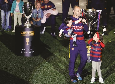 Barcelonau2019s Spanish midfielder Andres Iniesta holds his son Paolo next to his daughter Valeria as he speaks during celebrations at Camp Nou in Barcelona on Monday. The likes of Iniesta, Sergio Ramos, Cesc Fabregas are expected to play alongside a new generation of players in Vicente del Bosqueu2019s Spain team at Euro 2016. (AFP)