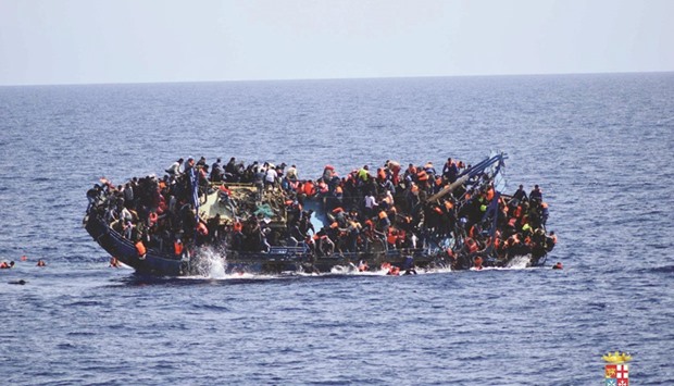 This handout picture released yesterday by the Italian Navy (Marina Militare) shows the overcrowded boat overturning off the Libyan coast.