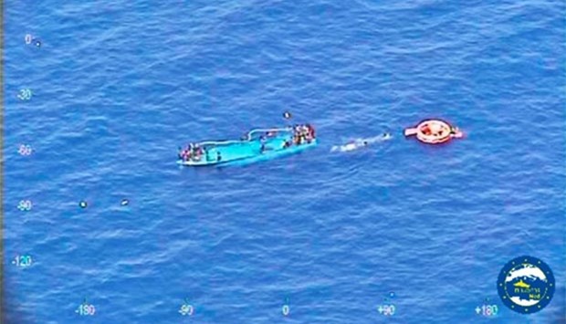 Migrants are seen on a partially submerged boat before being rescued by Spanish frigate Reina Sofia off the coast of Libya