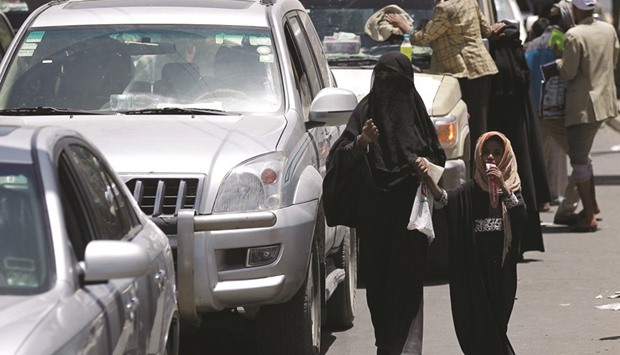A Yemeni woman and a girl walk past cars as they beg for money in a street in the Yemeni capital Sanaa. The United Nations says more than 80% of the population in Yemen is in dire need of food, medicine and other basic necessities and the crisis ranks as a u201cLevel 3 emergencyu201d.
