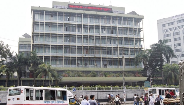 Commuters pass by the Bangladesh Bank building in Dhaka.