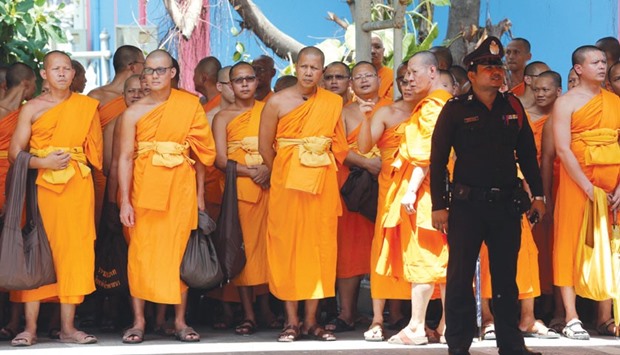 Buddhist monks gather outside Khlongluang provincial police station to show support for Phra Dhammachayo, the influential Buddhist abbot charged with money-laundering and receiving illegal donations, in Pathum Thani province, north of Bangkok.