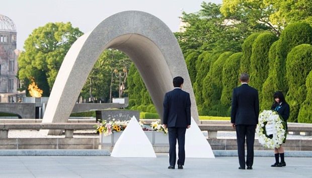 US President Barack Obama (2nd R) and Japanese Prime Minister Shinzo Abe (C) prepare to lay wreaths during a visit to the Hiroshima Peace Memorial Park in Hiroshima.