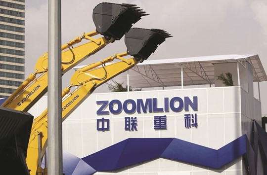 A Zoomlion company logo is seen next to its excavators at an exhibition in Shanghai. The construction machinery maker made a bid for US firm Terex to help them better cope with cooling Chinese and weak European demand.