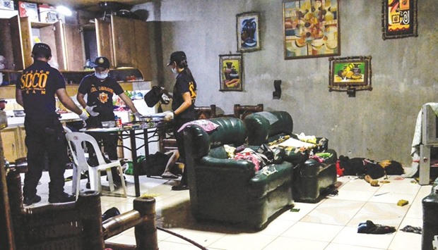 In this picture taken on Thursday, crime operatives (SOCO) inspect a room after an anti-illegal drug operation turned into an armed encounter which resulted in the killing of four unidentified suspects in Norzagaray, Bulacan, north of Manila.