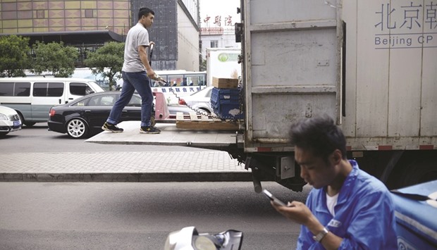 A  worker loading a truck in Beijing. China faces two separate challenges: the long-term issue of a declining potential growth rate and the immediate problem of below-potential actual growth. Among the long-term factors undermining potential growth are diminishing returns to scale, a widening income gap and a narrowing scope for technological catch-up through imitation.