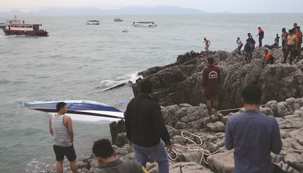 Rescue workers search for victims after a speedboat crashed and capsized in bad weather near the southern Thai island of Koh Samui.