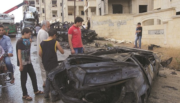 People inspect the wreckage of a car after an explosion occurred outside a mosque in the rebel-controlled city of Idlib, Syria yesterday.