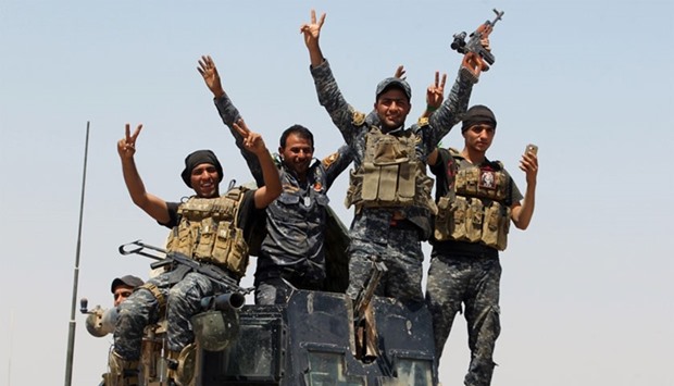 Pro-government forces fighters celebrate in the al-Sejar village, in Iraq's Anbar province, on May 27, 2016, as they take part in a major assault to retake the city of Fallujah, from the Islamic State (IS) group