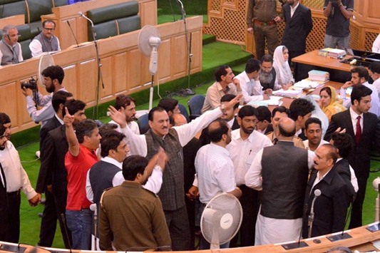 Members of the National Conference and Congress raise slogans during a protest inside the Jammu and Kashmir assembly in Srinagar yesterday.