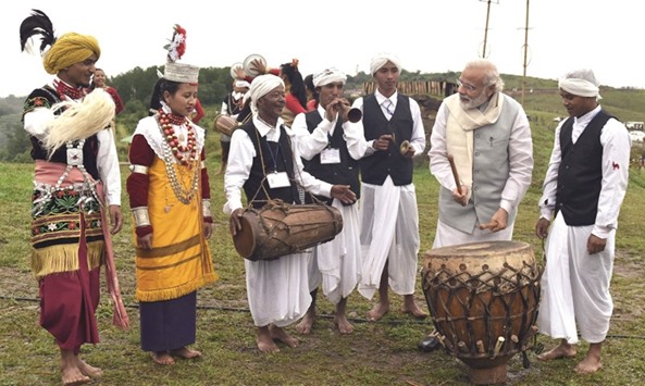 Prime Minister Narendra Modi plays a traditional drum during visit to Khasi Heritage Village in Mawphlang in the northeastern state of Meghalaya yesterday. Modi is the first prime minister to visit Mawphlang.