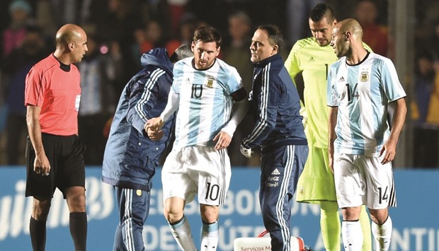 Argentinau2019s forward Lionel Messi (C) is assisted after being injured during a friendly match against Honduras at Bicentenario stadium in San Juan yesterday. (AFP)