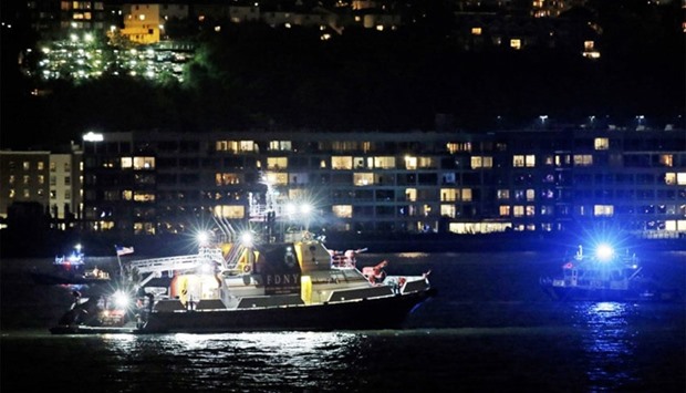 An FDNY fire department boat searches the Hudson River for the wreckage of a vintage P-47 Thunderbolt airplane that crashed in the river in New York City, New York