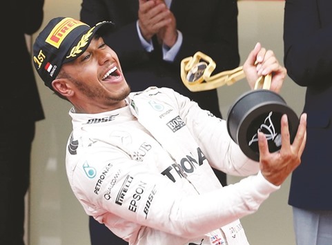 Mercedes driver Lewis Hamilton celebrates on the podium after winning Monaco Grand Prix yesterday. (Reuters)