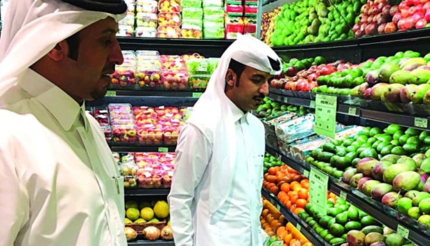Officials from the Ministry of Economy and Commerce inspecting a fruit and vegetable shop
