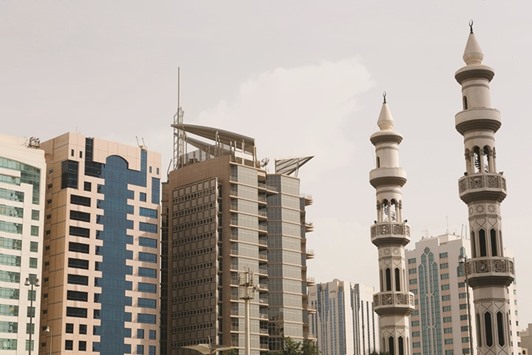 Minarets stand near skyscrapers in the city skyline in Abu Dhabi. Prices in the  UAE capitalu2019s residential sector were flat last year, after rising about 25% a year in 2013 and 2014.