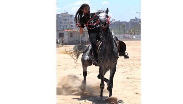 A Lebanese woman competes during a horse race festival on the coast shore of the city of Sidon, south Lebanon, yesterday.