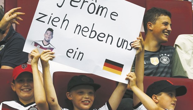 Young supporters of Germanyu2019s Jerome Boateng hold a placard reading u2018Jerome, please move next to usu2019 before the match.