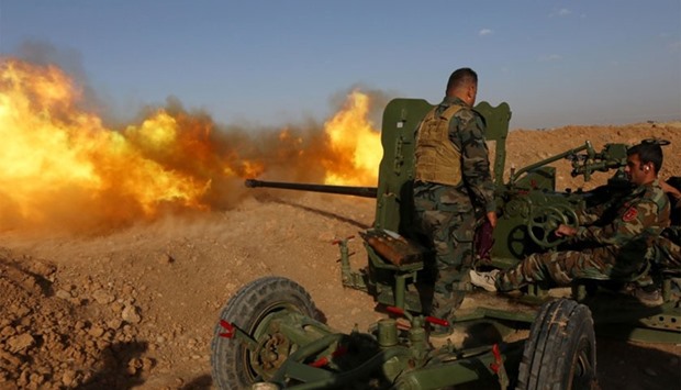 Iraqi Kurdish Peshmerga fighters fire an anti-tank cannon on the front line near Hasan Sham village, some 45 kilometres east of the city of Mosul, during an operation aimed at retaking areas from the Islamic State group