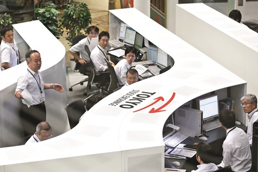Employees work at the Tokyo Stock Exchange. The Nikkei 225 closed up 1.4% to 17,068.02 points yesterday.