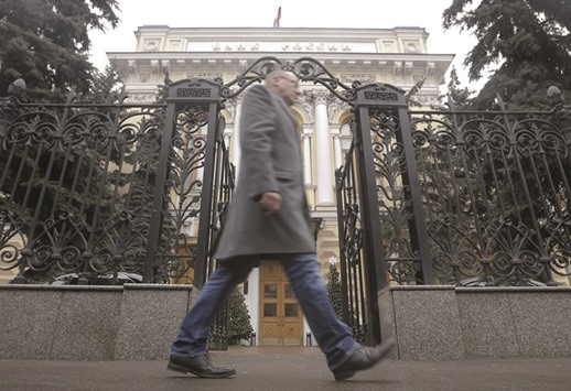 A man walks in front of the Russia central bank in Moscow. The Bank of Russia has shied away from the kind of policy zigzags that defined its first response to a currency crisis in 2014 and a recession that followed.