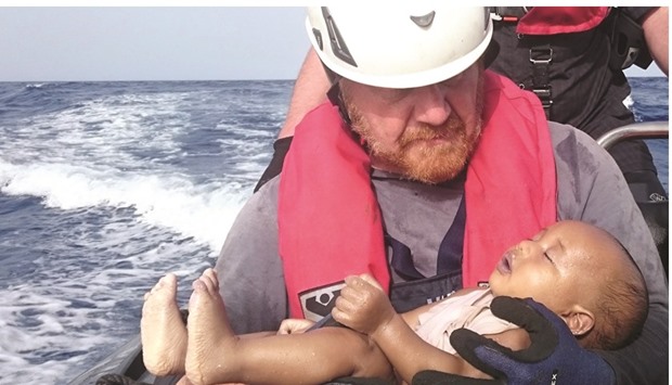 Martin from the humanitarian organisation Sea-Watch holds the drowned baby, off the Libyan coast on Friday.