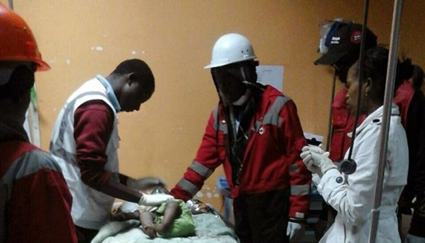 Kenyan Red Cross staff with an 18-month-old toddler rescued alive from the rubble of a six-storey building.