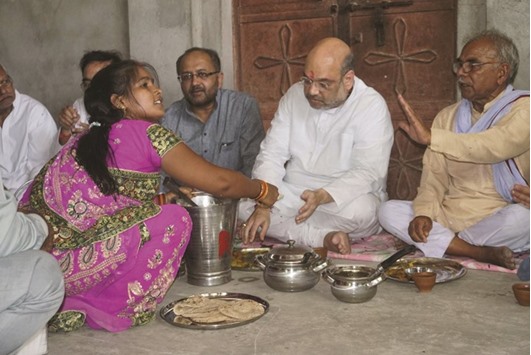 Bharatiya Janata Party chief Amit Shah eats lunch with a Dalit family in Jogiyapur, near Varanasi, as part of the partyu2019s mass contact expansion programme ahead of next yearu2019s assembly elections in Uttar Pradesh. The Dalit family is said to be a great supporter of Prime Minister Narendra Modi, who represents Varanasi in the Lok Sabha. However, Uttar Pradesh Chief Minister Akhilesh Yadav and Bahujan Samaj Party leader Mayawati  criticised Shah, saying the BJP chief was indulging in dramas.