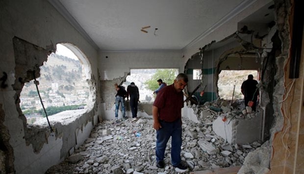 Palestinians inspect the apartment of Palestinian assailant Zeid Amer, who is held in an Israeli prison, after it was destroyed by Israeli troops in Nablus on Tuesday.